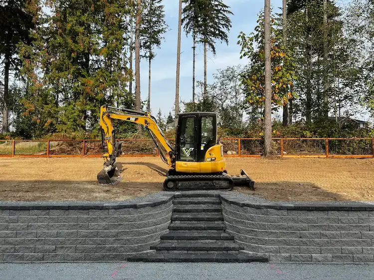 Variant Construction excavator sitting on the top level of a freshly installed hardscape.